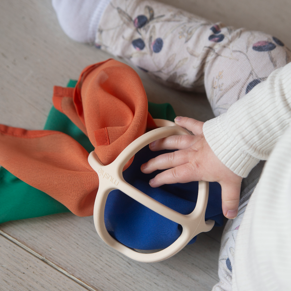 baby speelt met speeldoekje en babybal