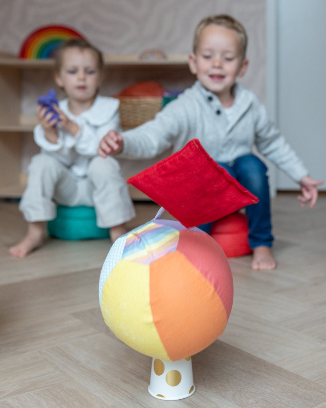 kind speelt met montessori speelgoed, regenboog pittenzakjes en ballonbal
